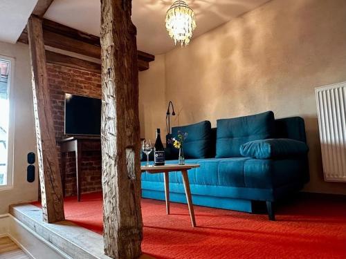 a living room with a blue couch and a table at Ferienwohnungen Weingut Pieper Basler in Offenburg