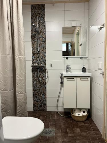 a bathroom with a sink and a shower at Tyylikäs koko perheen huoneisto in Vuokatti
