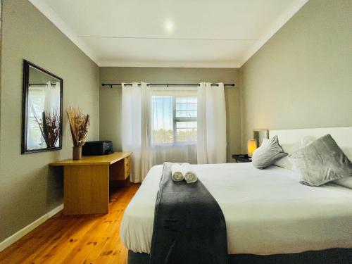 a bedroom with a large white bed and a window at Entire House in Beacon Bay - Family or Group Retreat - Swimming Pool - Multiple Braais in East London