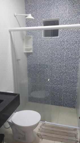 a bathroom with a toilet and a glass shower at Casa de praia com picina 2 in São José da Coroa Grande