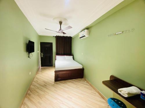 um quarto com uma cama numa parede verde em Abanaba lodge& Restaurant em Kumasi