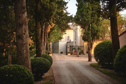 una entrada que conduce a una casa blanca con árboles en Villa Liverzano en Brisighella