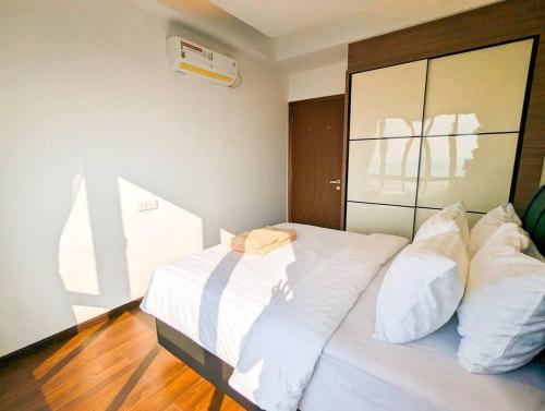 a bedroom with a bed with white sheets and pillows at Lovina 21-07 at Harbour Bay Residence(Near Ferry) in Batu Ampar