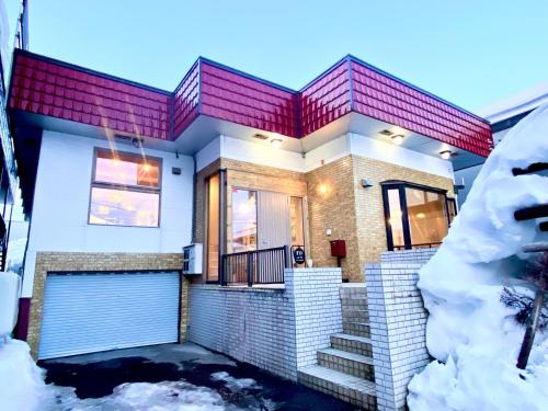 a house with a red roof in the snow at Abuta-gun - House - Vacation STAY 14526 in Kutchan