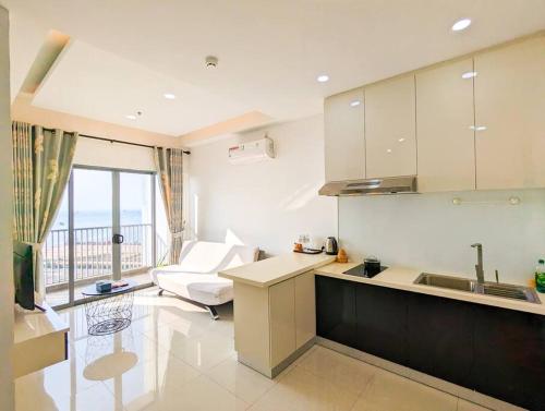 a kitchen with a sink and a couch in a room at Lovina 21-07 at Harbour Bay Residence(Near Ferry) in Batu Ampar