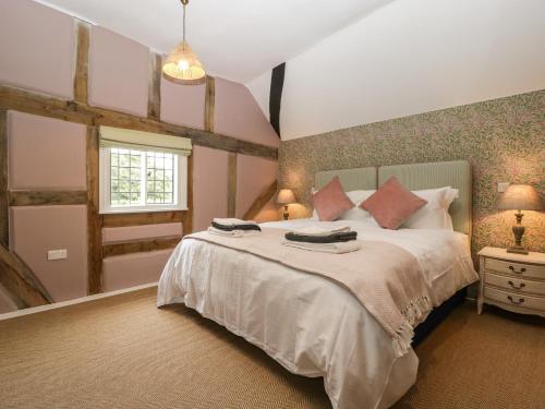 a bedroom with a large bed and a window at Lavender Cottage in Malvern Link