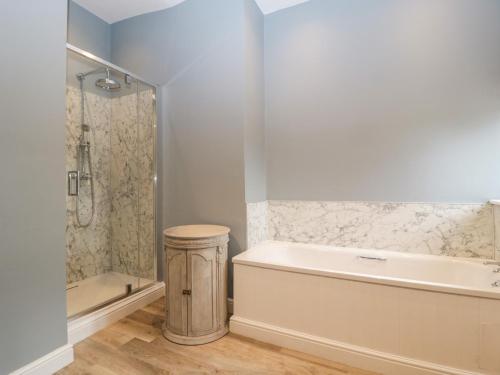 a bathroom with a bath tub and a shower at Lavender Cottage in Malvern Link