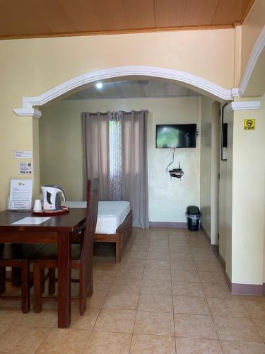 a room with a table and a bed and a table and chair at Seaside Beach Resort in San Fabian