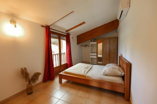 1 dormitorio con cama y ventana grande en Domaine des Arcs, en Saint-Martin-de-Londres