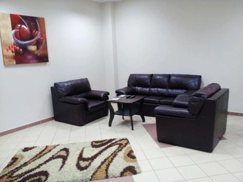 a living room with two leather chairs and a table at Hostel na Fali in Gollnow