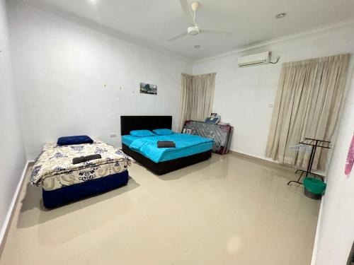 a bedroom with two beds and a ceiling fan at EMPIRE LUXURY HOMESTAY PAKA in Paka
