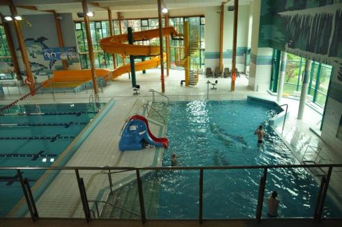 a large indoor swimming pool with a slide in it at Hostel na Fali in Goleniów