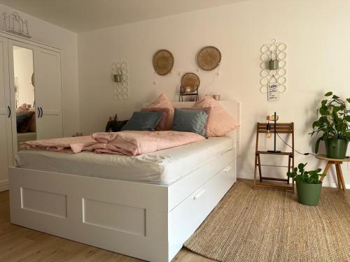een slaapkamer met een wit bed met roze lakens bij Olaf und Hildegard in Bad Wildbad