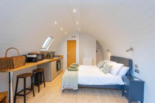 a small bedroom with a bed and a kitchen at The Plough Inn Cabins in Ramsden