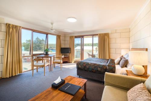 a hotel room with a bed and a living room at Loch Ard Motor Inn in Port Campbell