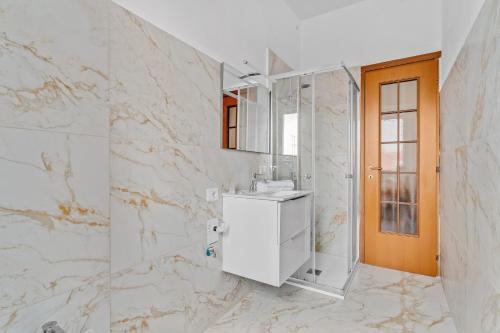 Baño blanco con lavabo y espejo en FA 333 - Spacious apartment with views of Milan - en Milán