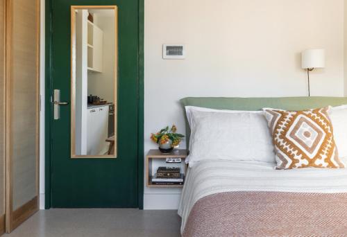 a bedroom with a bed with a green wall at Mason & Fifth, Bermondsey in London
