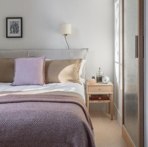 a bedroom with a bed and a table with a lamp at Mason & Fifth, Bermondsey in London