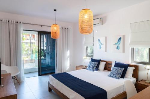 a bedroom with a large bed and two lights at Jolie situation, confortable et abordable in Rivière Noire
