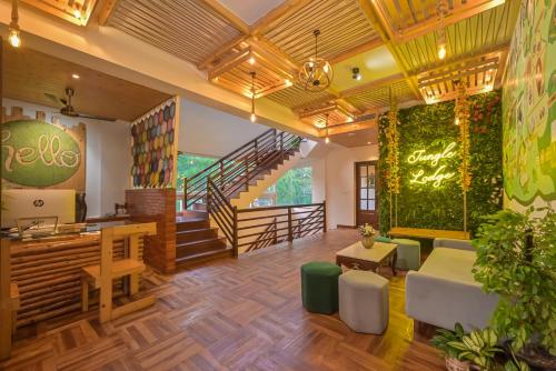 a lobby of a restaurant with a staircase and a table at Jungle Lodge Resort in Kasauli