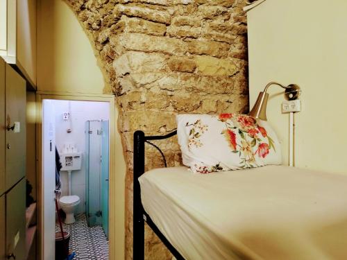 a bed in a room with a stone wall at PoliHosts Old Jaffa in Tel Aviv