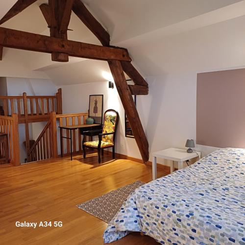 une chambre avec un lit et une table avec une chaise dans l'établissement Esterline, à Hautvillers