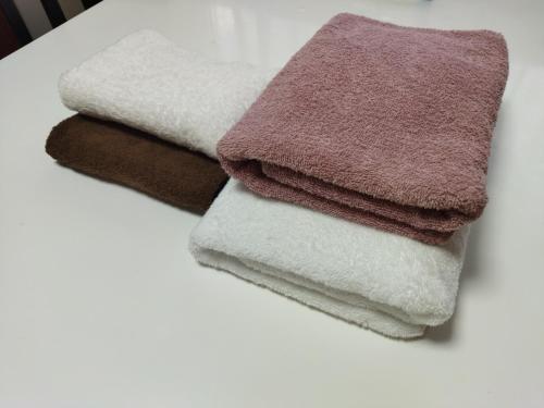 a pile of towels sitting on a table at Near Tram Apartment Okayama in Okayama