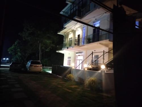 a white house with a car parked in front of it at night at Florence Villas in Jaffna
