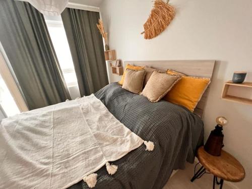 um quarto com uma cama com almofadas e uma janela em 2 Room / Central Railway / Free parking / Sauna em Oulu