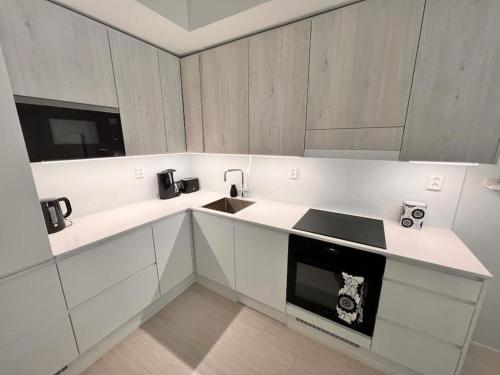 uma cozinha branca com um lavatório e um micro-ondas em 2 Room / Central Railway / Free parking / Sauna em Oulu