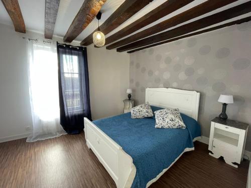 une chambre avec un lit avec des draps bleus et une fenêtre dans l'établissement L'Ecuyère-Maison de Ville-Secteur cathédrale-Parking privé gratuit, à Chartres