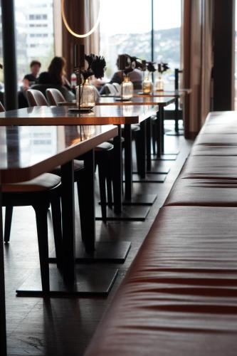 a row of wooden tables and chairs in a restaurant at Clarion Hotel Trondheim in Trondheim
