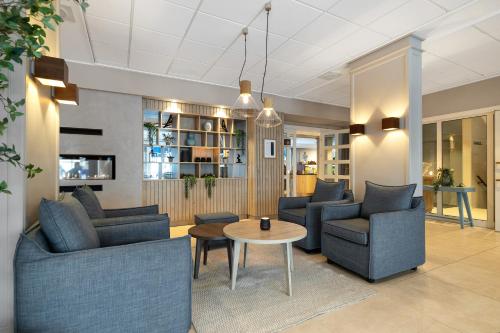 a lobby with couches and a table and chairs at Clarion Hotel Tyholmen in Arendal