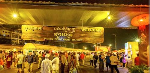 a crowd of people walking around a market at night at Somato Hotel in Phnom Penh