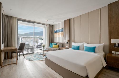 a bedroom with a large bed and a living room at Capital Beachfront Nha Trang in Nha Trang