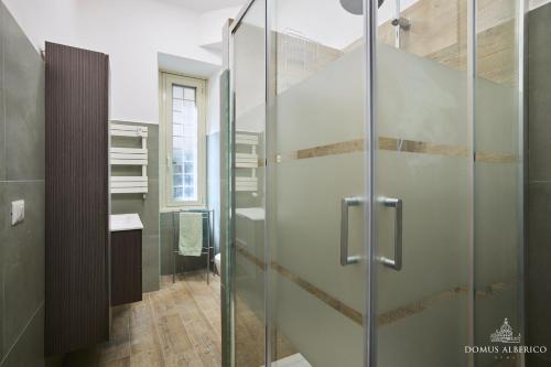 eine Glasdusche im Bad mit Waschbecken in der Unterkunft Domus Alberico 11 (Vaticano) in Rom