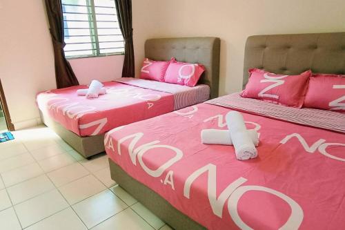 2 camas en una habitación con sábanas rosas y blancas en kulai2story 5R24pax nearJPO/JB airport ioiMall Aeon, en Kulai