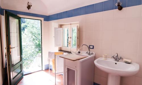bagno bianco con lavandino e lavandino di La Casa di Masaniello - Terrace & Seaview ad Atrani