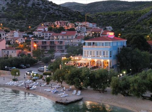 a hotel on the beach in a town next to the water at Villa Mediterana in Seget Vranjica