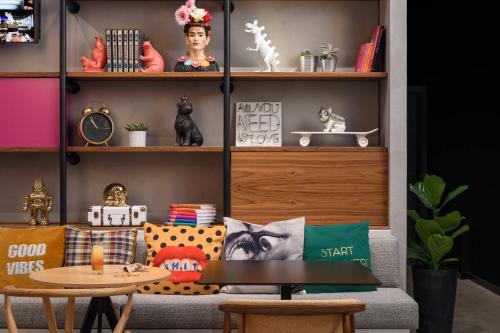 a living room with a couch with pillows and a table at Moxy Lisboa Oriente in Lisbon