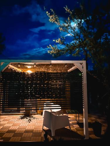 a white bench sitting on a patio at night at Elysian Fields - Tiny House 'Evergreen' in Sadu
