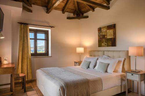 a bedroom with a large bed and a window at Eleonas Houses - Kardamili's Acqua Bliss in Kardamyli