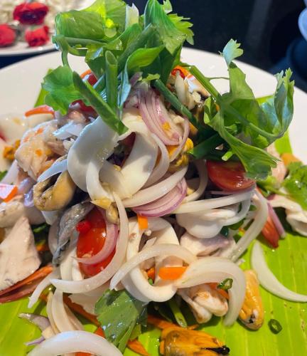 a salad with onions and vegetables on a plate at Villa Nilaya - Beachfront Villa - Hua Hin in Ban Bo Fai