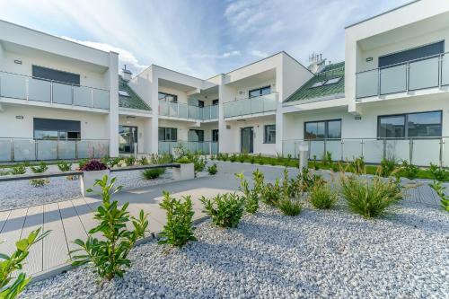 an apartment building with a courtyard with plants at Sunset Resort IV, Nadmorska 98B in Grzybowo