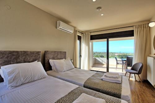 a bedroom with a bed and a view of a balcony at Phaedra by PosarelliVillas in Kounoupidhianá