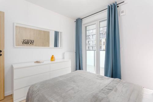 a bedroom with a bed and a dresser and a window at Enjoy! Ursus in Warsaw