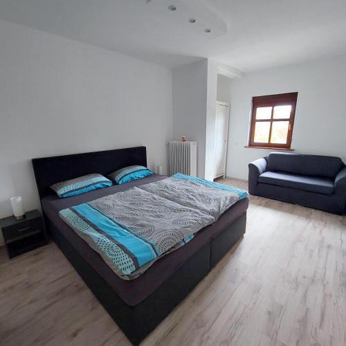 1 dormitorio con 1 cama grande y 1 sofá en Wolfi, en Sankt Wendel
