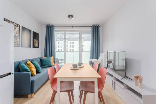a living room with a table and a blue couch at Enjoy! Ursus in Warsaw