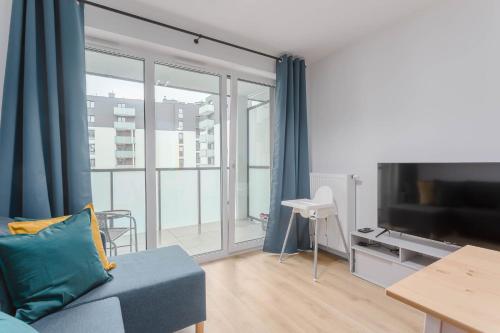 a living room with a couch and a large window at Enjoy! Ursus in Warsaw