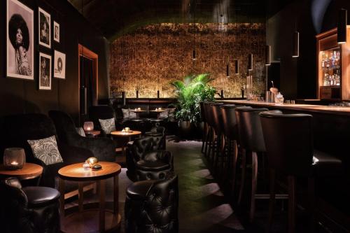 a restaurant with leather chairs and a bar at The Ritz-Carlton, Vienna in Vienna